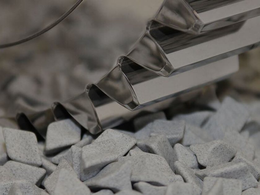 Ceramic finishing media polishing a metal part